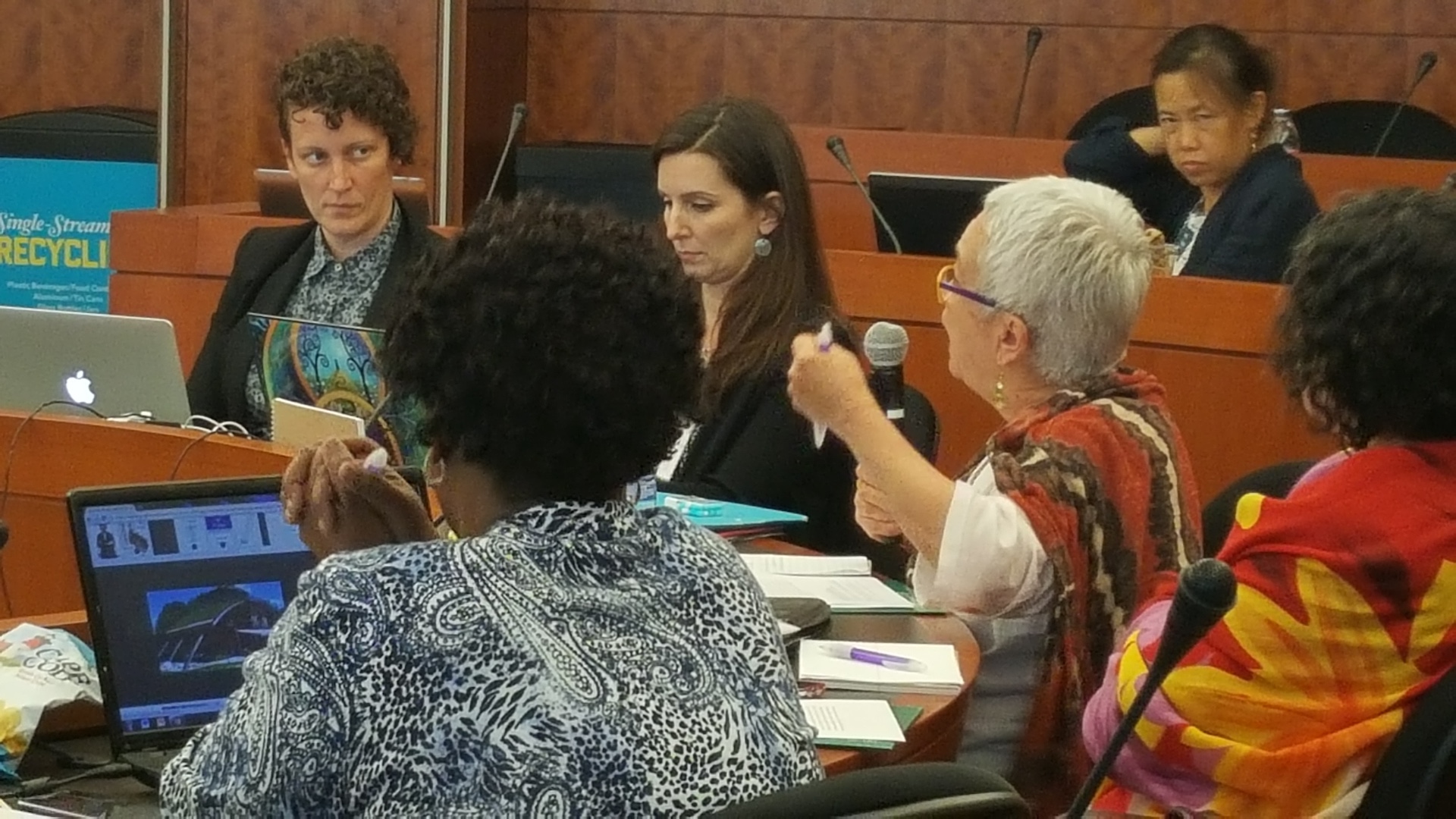 Woman speaking in mic at EGM good practices meeting